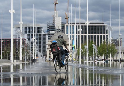 Bike with child seat riding between Centenary Square fountains